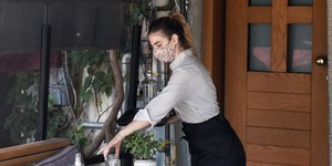 Σερβιτόρα μαζεύει ποτήρια από τραπέζι