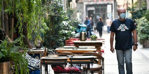 Περαστικός σε πεζόδρομο με τραπέζια