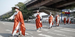 Βουδιστές με μάσκες περνούν διάβαση σε δρόμο στη Νότια Κορέα