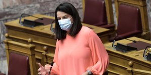 Η υπουργός παιδείας, Νίκη Κεραμέως με μάσκα και σομόν μπλούζα στα κυβερνητικά έδρανα της βουλής