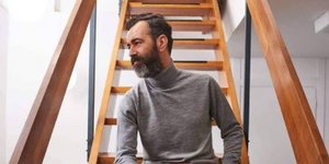 Ο Αγγελος Μπράτης κάθεται σε ξύλινη σκάλα