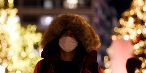 Άνδρας με μάσκα στο στολισμένο για τα Χριστούγεννα Σύνταγμα