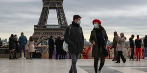 Κόσμος με μάσκες στο Παρίσι με φόντο τον πύργο του Αϊφελ