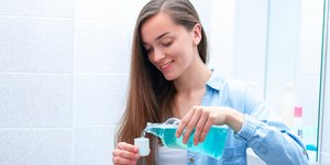 Γυναίκα ετοιμάζεται να κάνει γαργάρες με στοματικό διάλυμα