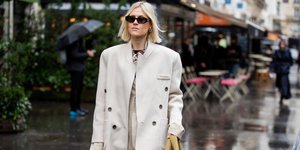 Γυναίκα με παλτό, γυαλιά και σκουλαρίκια