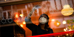 Γυναίκα ζωγραφίζει χριστουγεννιάτικα σχέδια σε τζάμι