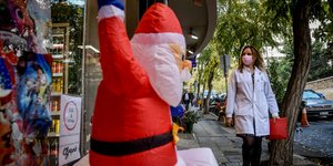 Ενας Αγιος Βασίλης έξω από κατάστημα με χριστουγεννιάτικα