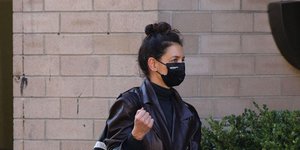 H Κέιτι Χολμς με μαύρη μάσκα και δερμάτινη καμπαρντίνα