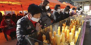 Κορεάτες προσεύχονται φορώντας μάσκες