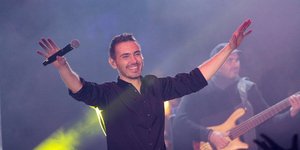 Ο Μιχάλης Χατζηγιάννης κρατά μικρόφωνο