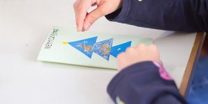 Παιδί φτιάχνει χριστουγεννιάτικη κάρτα