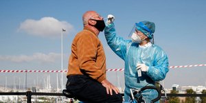 Εργαζόμενος του ΕΟΔΥ πραγματοποιεί δειγματοληψία για τεστ κορωνοϊού