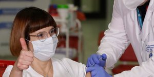 Νοσοκόμα στην Πολωνία σηκώνει τον αντίχειρα την ώρα που κάνει το εμβόλιο για τον κορωνοϊό