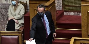Ο Σταϊκούρας δίνει έγγραφο σε βουλευτή στη Βουλή