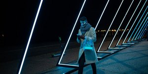 Άνδρας στην παραλία Θεσσαλονίκης περπατά ανάμεσα στον χριστουγεννιάτικο στολισμό