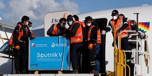 Εργαζόμενοι βγάζουν από αεροπλάνο εμβόλια για τον κορωνοϊό