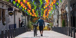 Ποδηλάτης με μάσκα περπατά σε δρόμο στην Κολομβία