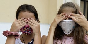 Δύο παιδιά με μάσκες για τον κορωνοϊό
