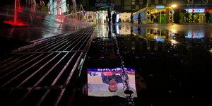 Η εικόνα του Κινέζου προέδρου αντανακλάται στο βρεγμένο πεζοδρόμιο
