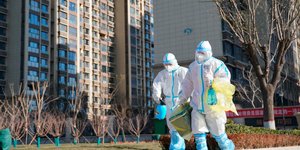 Εργαζόμενοι πάνε για απολύμανση σε πόλη της Κίνας