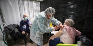 Νοσοκόμα χορηγεί το εμβόλιο κατά του κορωνοϊού σε πολίτη στη Γαλλία