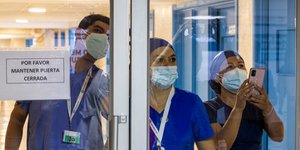 Γιατροί κοιτάζουν από το τζάμι πόρτας