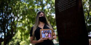 Γυναίκα κρατάει φωτογραφία της μητέρας της που πέθανε