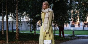 Γυναίκα με κίτρινο φόρεμα κρατά τσάντα 