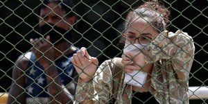 Γυναίκα κάθετε πίσω από σύρματα στην Βραζιλία