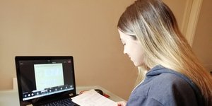 Μαθήτρια κρατά σημειώσεις σε μάθημα μέσω τηλεκπαίδευσης