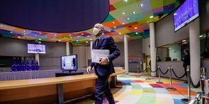 Ο Σαρλ Μισέλ στην αίθουσα συνεδριάσεων της ΕΕ με μάσκα, κρατώντας έγγραφα