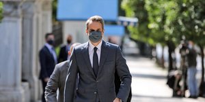 Ο Κυριάκος Μητσοτάκης περπατά έξω από το προεδρικό Μέγαρο φορώντας μάσκα