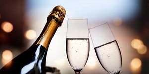 Μπουκάλι σαμπάνιας πλάι σε δυο ποτήρια για αφρώδη οίνο