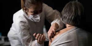 Νοσοκόμα κάνει το εμβόλιο για τον κορωνοϊό σε πολίτη στη Γαλλία