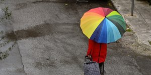 Γυναίκα κρατάει ομπρέλα στα χρώματα του ουράνιου τόξου