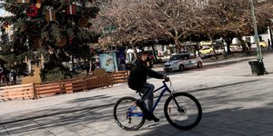 Νεαρός με ποδήλατο στο κέντρο της Αθήνας, στην στολισμένη πλατεία Συντάγματος