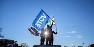 Υποστηρικτές της Καμάλα Χάρις με σημαίες που γράφουν «ψηφίστε» στη Τζόρτζια των ΗΠΑ