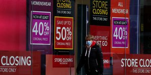 Πολίτης με μάσκα μπροστά από βιτρίνα καταστήματος στο Λονδίνο