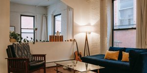 Σαλόνι με φωτιστικό δίπλα στον μπλε καναπέ