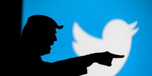 Η σκιά του Ντόναλντ Τραμπ μπροστά από το λογότυπο του twitter