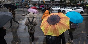 Κόσμος με ομπρέλες σε δρόμο της Θεσσαλονίκης