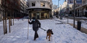 Κάτοικος της Μαδρίτης στην Ισπανία βγάζει βόλτα τον σκύλο του στη χιονισμένη πόλη