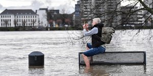 Κάτοικος της Κολωνίας φωτογραφίζει πλημμυρισμένη όχθη του Ρήνου