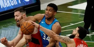 Ο Αντετοκούνμπο ανάμεσα σε δύο παίκτες των Ράπτορς