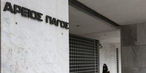 Γυναίκα περνά έξω από τον Αρειο Πάγο