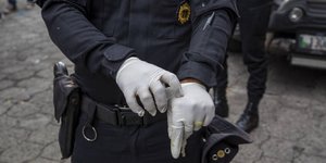 Άνδρας της αστυνομίας φορά προστατευτικά γάντια