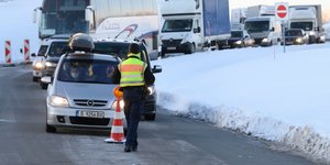 Αστυνομικός μπροστά από ουρά αυτοκινήτων σε περιοχή με χιόνια στην Αυστρία
