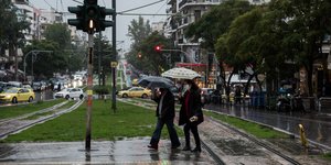 δύο γυναίκες περπατούν κρατώντας ομπρέλες