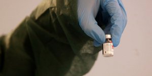 Νοσοκόμος με φιαλίδιο εμβολίου ενάντια στον κορωνοϊό στο χέρι