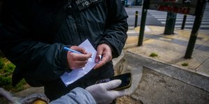 Αστυνομικός πραγματοποιεί έλεγχο για πιστοποιητικό κατ' εξαίρεση μετακίνησης εν μέσω lockdown